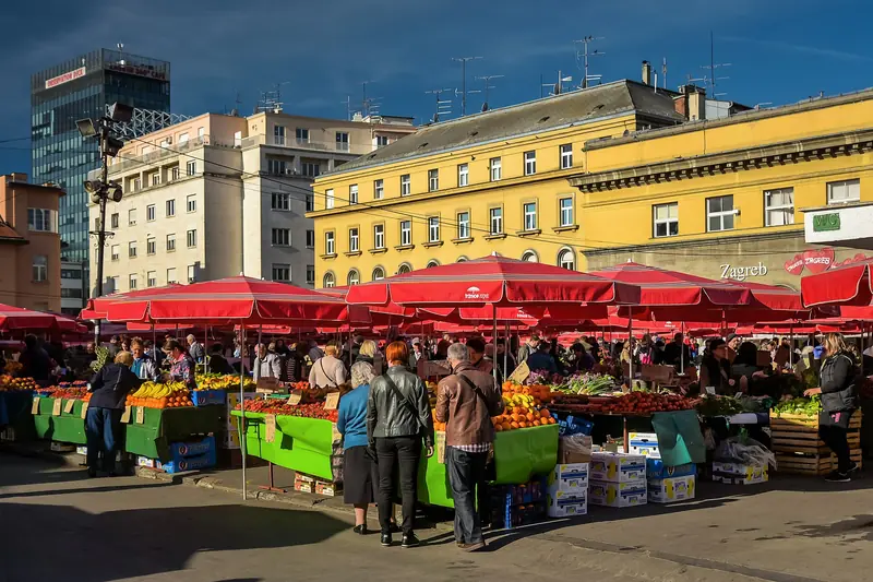 Obst- und Gemüsestände unter roten Schirmen auf dem Dolac-Markt in Zagreb